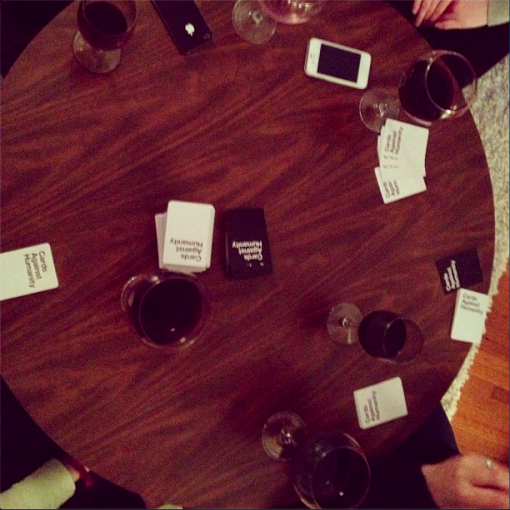 cards against humanity, iphones and drinks around the table